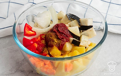 В подходящей по размеру емкости смешайте нарезанные овощи, томатную пасту, соль и специи.