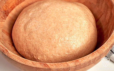 Приготовьте тесто. Смешайте в миске воду с солью и сахаром. Засыпьте в воду смесь разной муки, сделайте в ней воронку и положите туда дрожжи. Замесите тесто до гладкой однородной массы, прикройте полотенцем и оставьте на 40-50 минут.