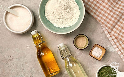 Муку просейте через мелкое сито, воду нагрейте заранее, чтобы она была чуть выше комнатной температуры. Для начинки сделайте смесь из сухой петрушки и оливкового масла. Подготовьте духовку, противень застелите пергаментной бумагой.