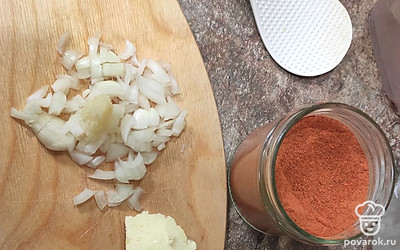 Почистить лук и 3 зубчика чеснока. Лук нарезать мелко, чеснок пропустить через пресс. Отправить в сковородку, установив средний огонь.