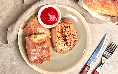 Нарежьте багет с сушеной петрушкой ломтиками. Он будет хорошо сочетаться с рыбными блюдами — например, со стейком на гриле.