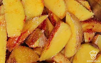 Посолите картофель. Добавьте паприку, гранулированный чеснок и подсолнечное масло. Тщательно перемешайте.