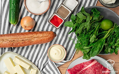 Приготовьте необходимые продукты. Мясо, овощи и зелень вымойте, обсушите на бумажных полотенцах. Часть огурца нарежьте тонкими слайсами при помощи овощечистки. Оставшуюся — кубиками. Зелень мелко нарежьте. Репчатый лук нашинкуйте кольцами. Сливочное масло заранее достаньте из холодильника, оно должно быть комнатной температуры. Репчатый лук очистите.