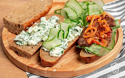 Соберите багет. Половинку багета смажьте соусом, положите листья щавеля, затем обжаренные луковые кольца, огуречные слайсы, говядину. Снова смажьте соусом, накройте второй половинкой багета.