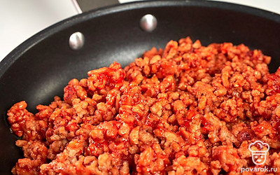 Займитесь фаршем. Фарш выложите на сухую разогретую сковороду, добавьте томатный соус, посолите, обжаривайте на среднем огне до испарения жидкости 7-10 минут.