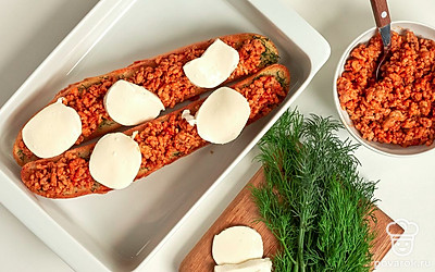 Сформируйте багеты и запеките их. Кусочки багета достаньте из духовки, разложите на них обжаренный фарш, сверху уложите кусочки моцареллы. Поставьте в духовку на 10-12 минут.