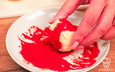 Приготовьте шарики. Смешайте в миске тертый сыр, измельченный чеснок и майонез. Сформируйте из массы небольшие шарики. Выложите на разные тарелки нарезанный укроп, паприку и кунжут. Каждый шарик обваляйте в одной из посыпок.