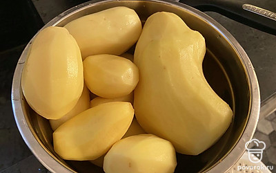 Промойте и почистите картошку. А также поставьте разогреваться духовку до 180 градусов.