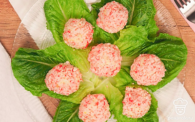 Подавайте сырно-крабовые шарики на тарелке, выложенной листьями салата.