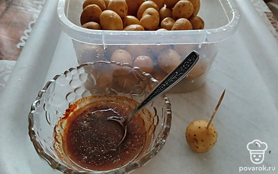 Приготовить маринад для картошки. Смешать 2 ложки растительного масла с солью, перцем. Можно добавить мускатный орех. Каждую картошечку проколоть в нескольких местах зубочисткой, чтобы клубни лучше промариновались.