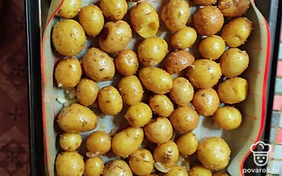 Когда картошка замаринуется, выложить на противень. Отправить запекаться в духовку на 30 минут, до готовности.