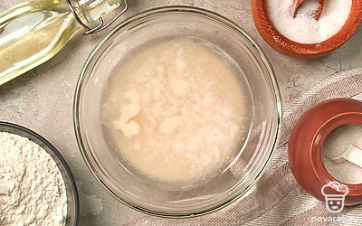 Займитесь опарой. В небольшой миске соедините дрожжи, сахар и 2 ст. л. муки. Влейте полстакана воды, размешайте. Оставьте на 15-20 минут.