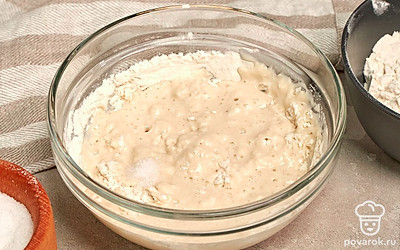 Приступите к замесу теста. Муку просейте в подходящую по объему миску, добавьте соль и шалот. Влейте оставшуюся воду, немного перемешайте и соедините с дрожжевой основой. Вымешивайте до эластичности примерно 12-15 минут. Оставьте в тепле для подъема на 1-1,5 часа.