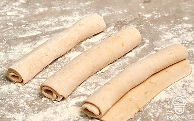 Когда тесто увеличится в два раза, переходите к формовке. Насыпьте на рабочую поверхность немного муки, выложите тесто, обомните, раскатайте в лепешку, разделите на 3 части. Каждой части придайте форму багета. Оставьте на 15-20 минут под накрытым полотенцем.