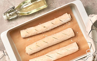 Выпеките багеты. Пока заготовки подходят, включите духовку на 220 градусов, на дно поставьте миску с водой. По истечении указанного времени переложите заготовки изделия на противень, оставляя между ними расстояние в 3-4 см. Смажьте маслом, которое осталось после обжарки лука, сделайте диагональные надрезы и отправьте выпекаться на 30 минут.