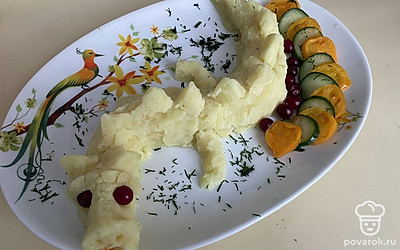 Сформируйте ложкой из получившимся пюре фигуру в форме дракона. Лучше это делать на плоском блюде. Используйте ягоды брусники для глаз. Для языка возьмите кусочек моркови.