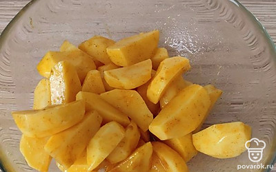 Добавьте к долькам картофеля приправу и растительное масло. Все перемешайте.