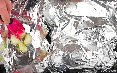 Рядом в фольгу положите зубчики чеснока, также смажьте их оливковым маслом. Заверните чеснок в фольгу. Отправьте противень в духовку на 40-50 минут при 200 °С.