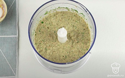 Разрежьте баклажан пополам и отделите мякоть от кожуры с помощью ложки. Положите мякоть баклажана в чашу блендера. Добавьте кунжут и чеснок. Добавьте оливковое масло, лимонный сок, сметану и щепотку соли. Добавьте листья петрушки. Измельчите всё с помощью блендера до однородной консистенции.
