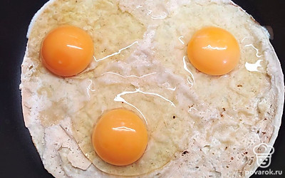 Разбейте яйца на лаваш.