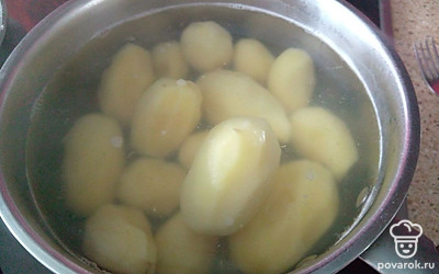 Картофель почистите, переложите в кастрюлю, залейте холодной водой и поставьте на огонь. Варите до готовности 25 минут. 