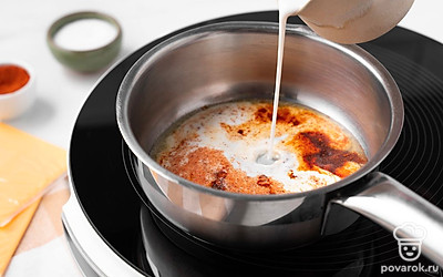 Налейте в сотейник молоко, всыпьте 0,5 ч.л. сахара, соль и молотый перец чили. Размешайте до однородного состояния. Положите в получившийся соус ломтики плавленого сыра. Прогрейте, помешивая, пока сыр полностью не расплавится.