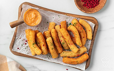 Подайте картофельные чуррос с острым сырным соусом.