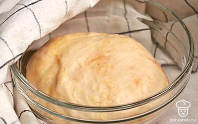 Займитесь подготовкой теста. В теплую воду всыпьте дрожжи и сахар, размешайте. Дайте дрожжам активироваться в течение четверти часа. Затем влейте масло, добавьте соль, перемешайте. Добавьте муку, паприку, куркуму, чеснок. Тщательно перемешайте компоненты. Прикройте полотенцем и отправьте для подъема в теплое место на 1 час. По истечении указанного времени подошедшее тесто обомните, вымешивайте в течение 15 минут. Затем снова оставьте на час в теплом месте.