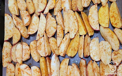 Картофельные ломтики выложите на противень, застеленный пергаментной бумагой. 