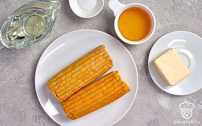 Кукурузу очистите от листьев и волокон, помойте. Сливочное масло заранее достаньте из холодильника, чтобы оно стало мягким. Разогрейте духовку до 180 градусов.
