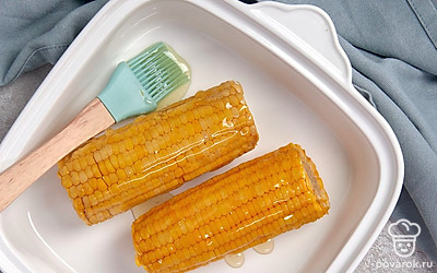 Запеките кукурузу. Положите кукурузу в форму для запекания и поставьте в разогретую духовку на 20 минут. Переверните початки на другую сторону и отправьте в духовку еще на 15 минут.