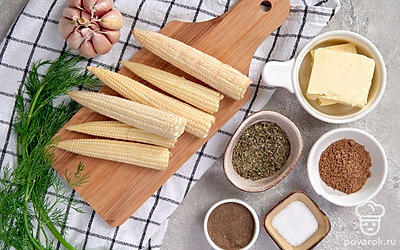 Сливочное масло достаньте заранее из холодильника. Укроп и петрушку промойте и обсушите бумажным полотенцем, мелко нарежьте. Кукурузу промойте. Чеснок очистите от шелухи, вымойте и измельчите в прессе.