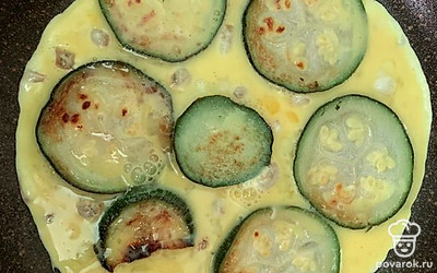 Залить взбитым яйцом с молоком. Накрыть крышкой и оставить на сковороде, на медленном огне, минут на 5.