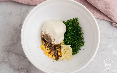 Вареные яйца очистите от скорлупы, разрежьте пополам и извлеките желтки. Натрите их на мелкой терке. В подходящую емкость выложите желтки, майонез, измельченные чеснок и укроп. Посолите и поперчите на свой вкус, смешайте до однородности.