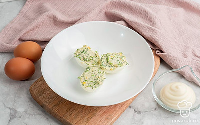 Яйца фаршированные чесноком и укропом выложите на тарелку и украсьте на свой вкус. Приятного аппетита!