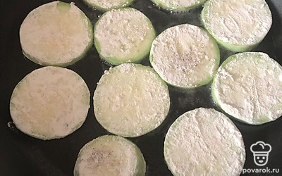 Обжарить кабачки с одной стороны в муке, добавив масло в разогретую сковороду.