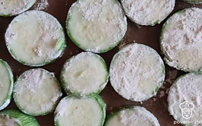 Смешать муку и соль. Обмакнуть каждый кабачковый кружок в муку и выложить на смазанный маслом противень. Поставить выпекать в духовку. 