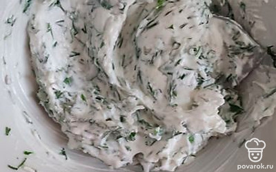 Пока кабачки выпекаются, сделать начинку: смешать сметану, нарезанную зелень, натертый чеснок, посолить. Вытащить кабачки. Немного остудить и промазать каждый кружок начинкой. 