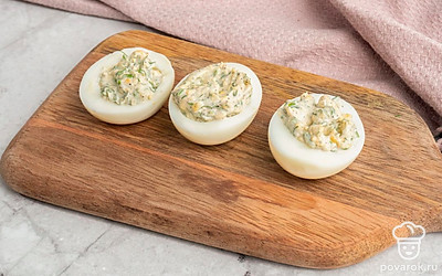 Полученную смесь выложите в готовые половинки яичного белка.