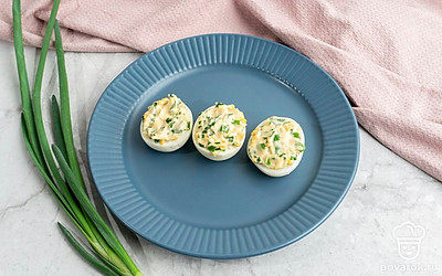 Яйца фаршированные зеленым луком, чесноком и желтком выложите на тарелку и украсьте на свой вкус. Приятного аппетита!