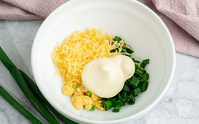 Вареные яйца очистите от скорлупы, разрежьте пополам и извлеките желтки. Натрите на мелкой терке желтки и сыр. В подходящую емкость выложите желтки, сыр, майонез и измельченный зеленый лук. Посолите на свой вкус и смешайте до однородности.