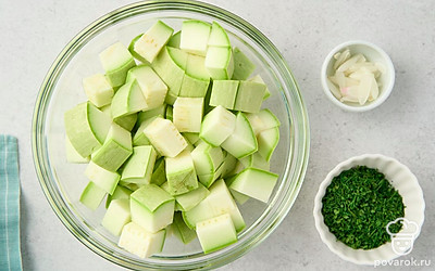 Нарежьте зубчик чеснока тонкими пластинками. Мелко порубите кисточки укропа. Нарежьте кабачки кубиками или брусочками шириной примерно 1,5 см. Выложите кусочки кабачков в миску.