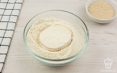 Обваляйте ломтики колбасного сыра сначала в муке.