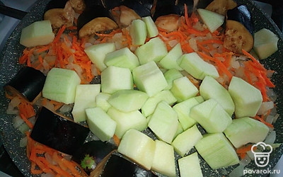 На растительном масле слегка обжарьте лук с морковью. Добавьте кабачки с баклажанами. Обжаривайте овощи около 10 минут, помешивая.