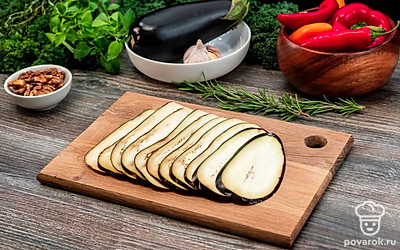 Нарежьте баклажаны вдоль на пластины толщиной 3-4 мм.