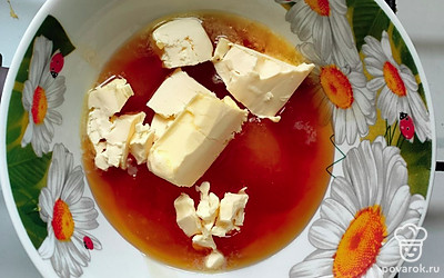 Растопите на водяной бане  мед. Когда он станет жидким, добавьте сливочное масло. Перемешайте, но не доводите до кипения, огонь должен быть минимальный.