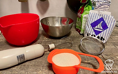 Приготовьте бисквитные коржи для торта. Возьмите 5 яиц, они должны быть холодными, чистыми и сухими. В сухой и обезжиренной чаше отделите белки от желтков. Этот момент важен, чтобы правильно взбился белок.