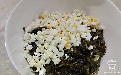 Добавьте морскую капусту и нарезанные отварные яйца.