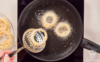 Приготовьте луковые кольца во фритюрнице. Налейте во фритюрницу или в глубокую сковородку масло. Включите соответствующий температурный режим. В горячее масло опустите луковые кольца на 2-3 минуты. Готовые кольца положите на бумажное полотенце, чтобы впитался лишний жир.