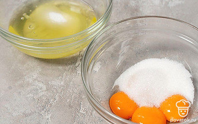 Поделите сахар на 2 части. Одну половину добавьте к белкам, другую — к желткам.